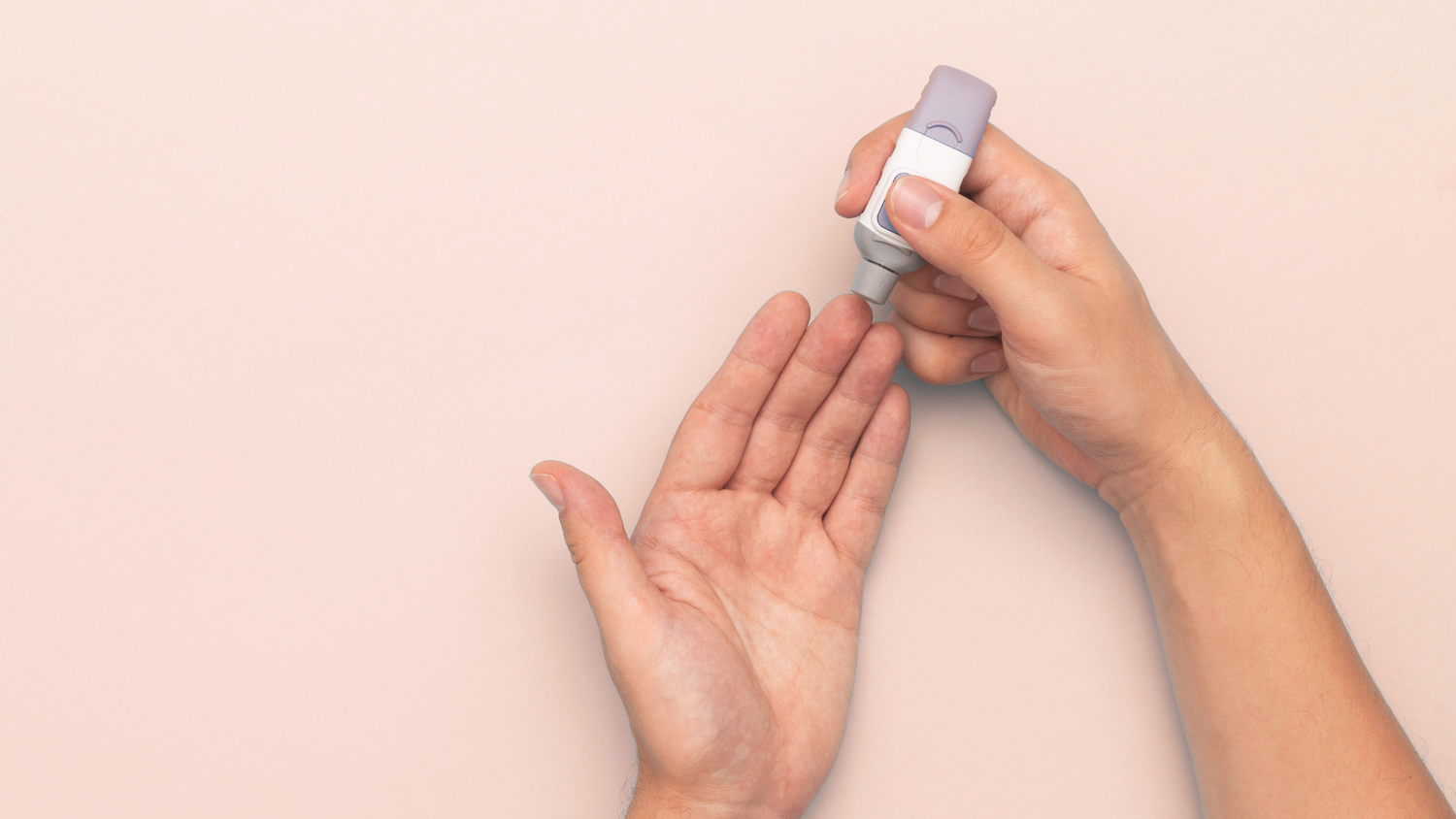 Person finger pricking on a beige background